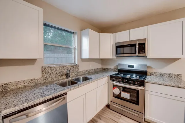 a kitchen with a sink stove and microwave