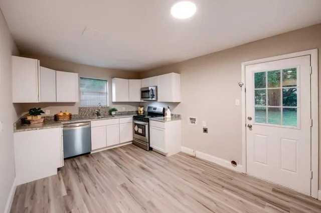 a kitchen with wooden floors and white appliances