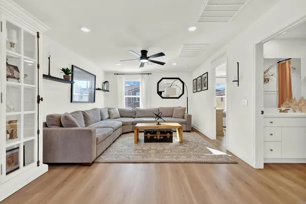 a living room with furniture and a ceiling fan