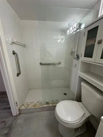 a bathroom with a toilet and a shower