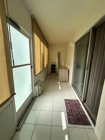 a view of a hallway with wooden floor and furniture