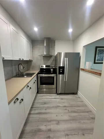 a kitchen with granite countertop a refrigerator and a sink