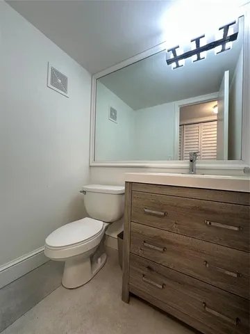 a bathroom with a toilet a sink and mirror