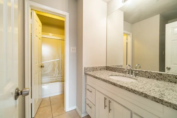 a bathroom with a granite countertop sink and a mirror