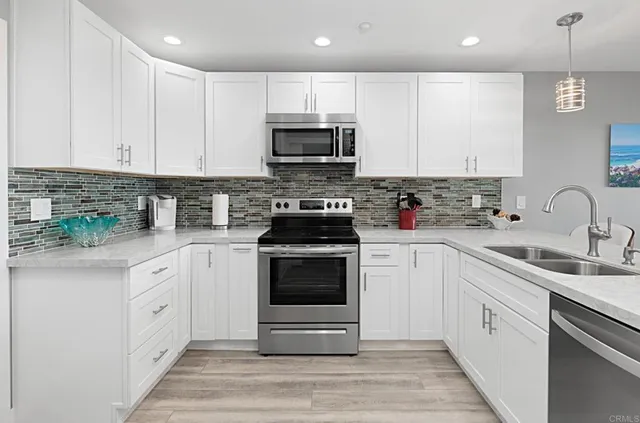 a kitchen with white cabinets stainless steel appliances and sink