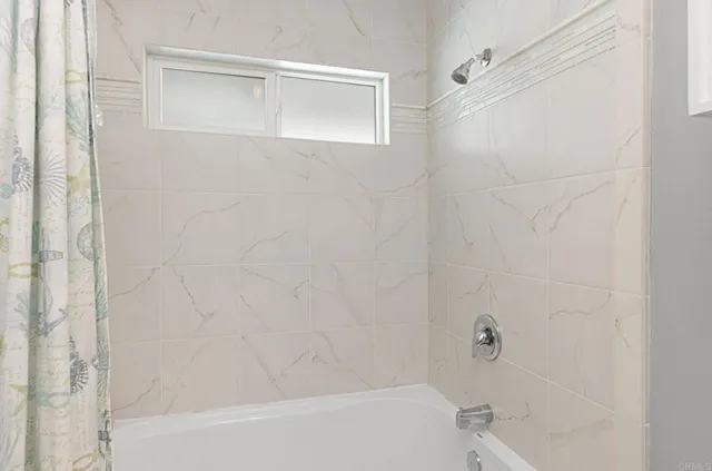 a bedroom with a bed and a lamp on dresser