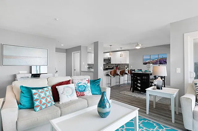 a living room with furniture and a dining table with kitchen view