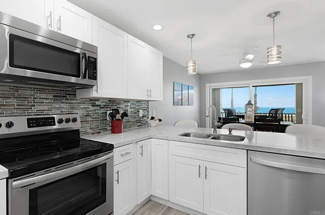 a kitchen with a sink stainless steel appliances and white cabinets