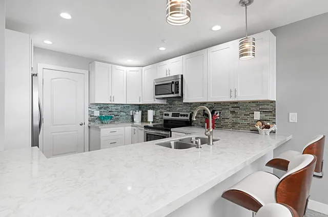 a kitchen with stainless steel appliances granite countertop a sink refrigerator and microwave