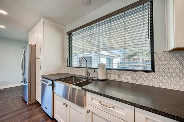 a kitchen with granite countertop a sink and a refrigerator