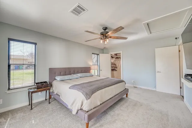 a bedroom with a large bed and a chandelier