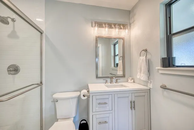 a bathroom with a sink a toilet and shower