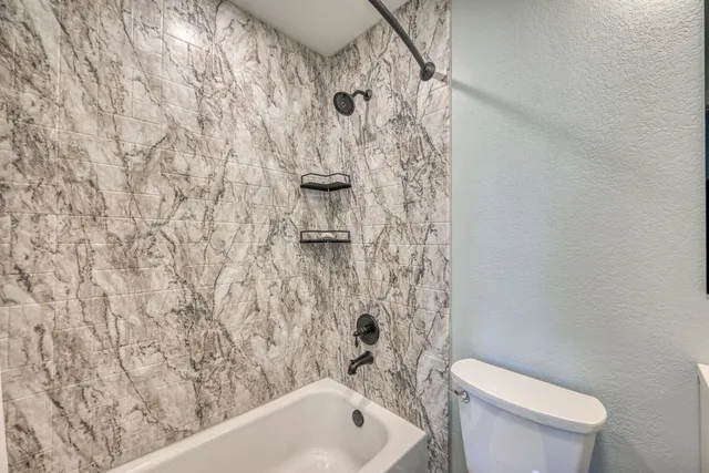 a bathroom with a toilet and a shower curtain