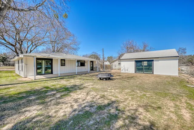 a view of a house with a yard and sitting area