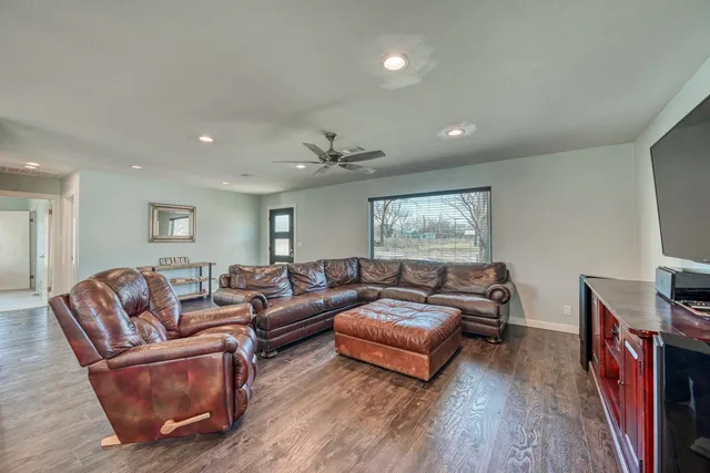 a living room with furniture and a wooden floor