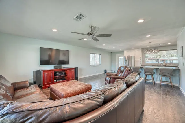 a living room with furniture kitchen view and a flat screen tv