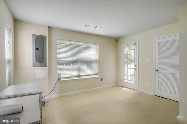 a view of an empty room with a window and a bathroom