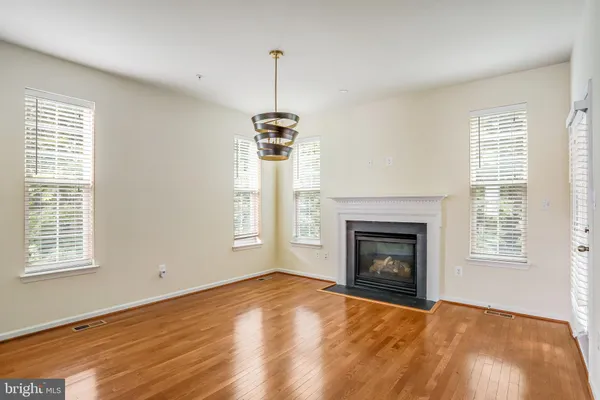 a view of empty room with wooden floor fireplace and windows