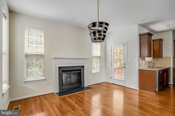 a view of an empty room with a fireplace and window