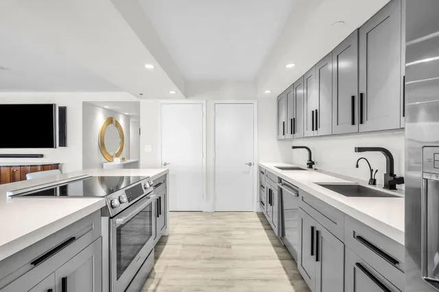 a kitchen with white cabinets and sink