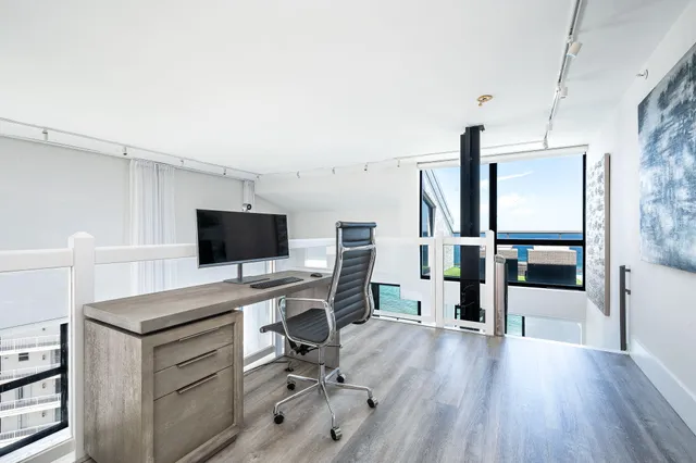 a spacious bedroom with a bed and large wooden floor