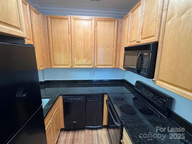 a kitchen with granite countertop wood cabinets and a stove