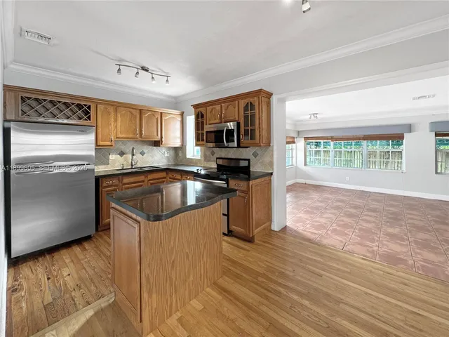 a kitchen with granite countertop a sink and a stove top oven