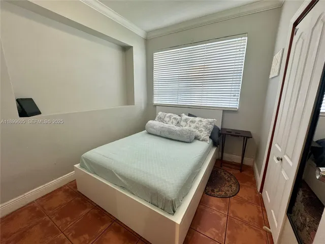a bed sitting in a bedroom next to a window