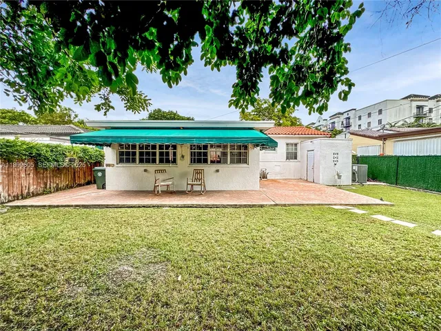 a view of a house with pool and a yard