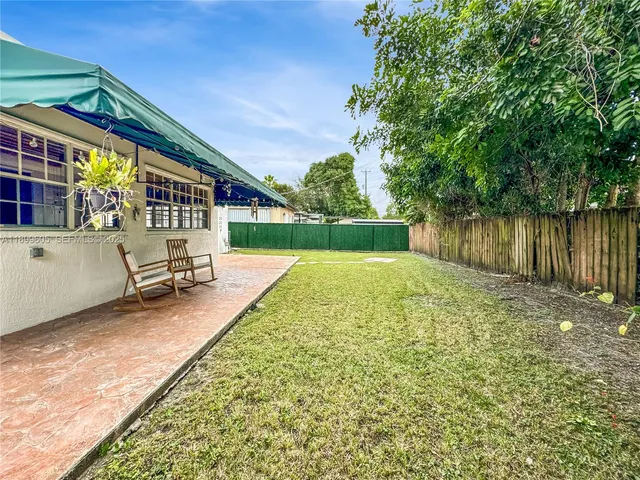 a view of house with swimming pool outdoor seating and green space