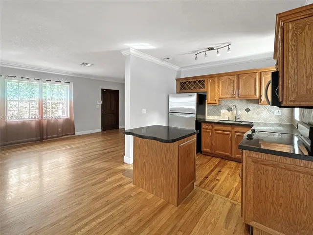 a kitchen with stainless steel appliances granite countertop a sink stove and refrigerator