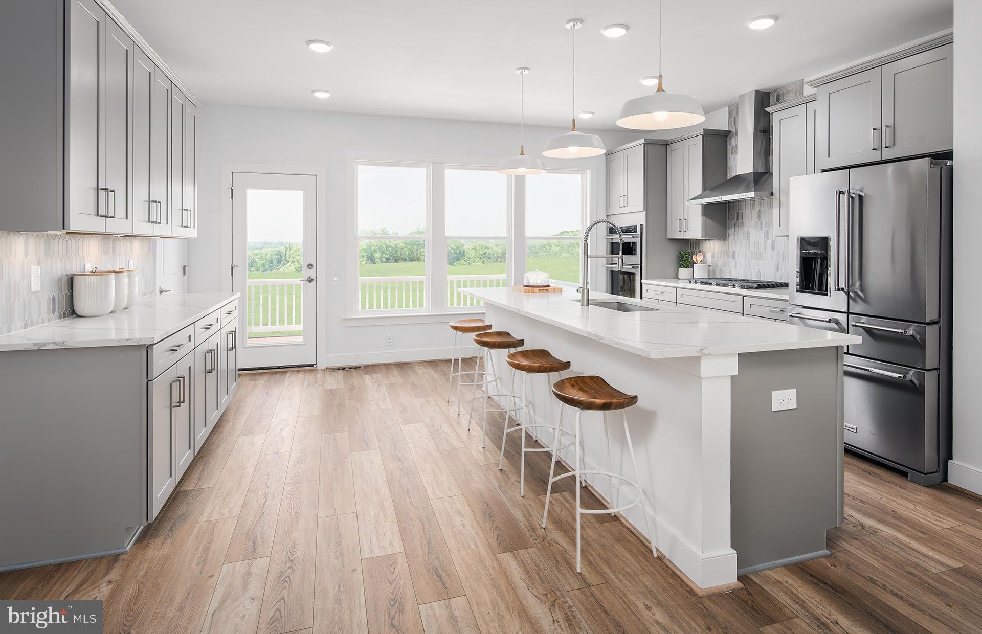 303 Backwater Way Laurel, MD 20724 - Photo 2 of 33 a kitchen with stainless steel appliances a refrigerator a sink dishwasher a stove and white countertops with wooden floor