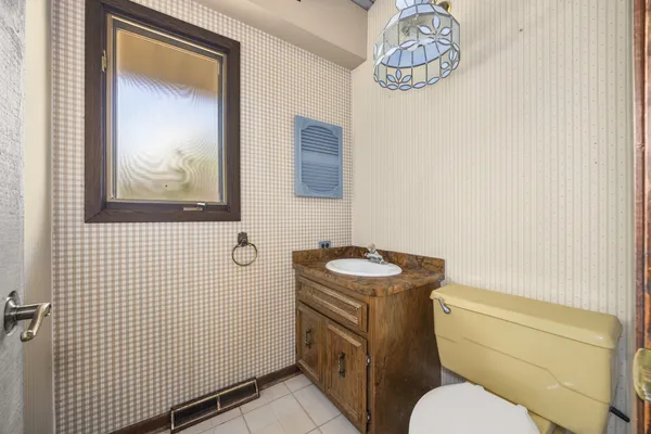 a bathroom with a toilet a sink and mirror