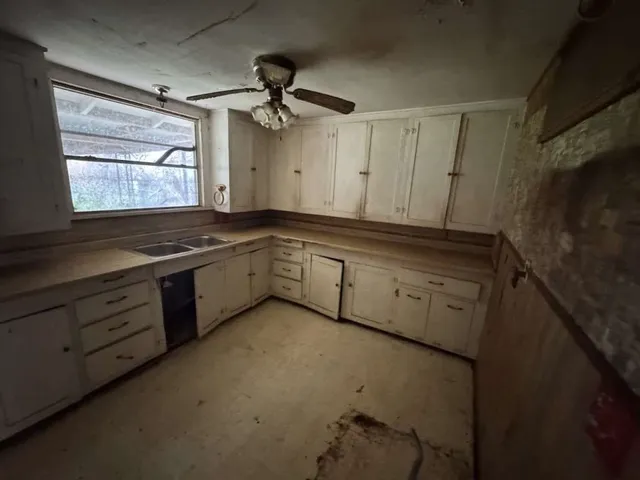 a kitchen with granite countertop white cabinets white appliances with a sink and dishwasher