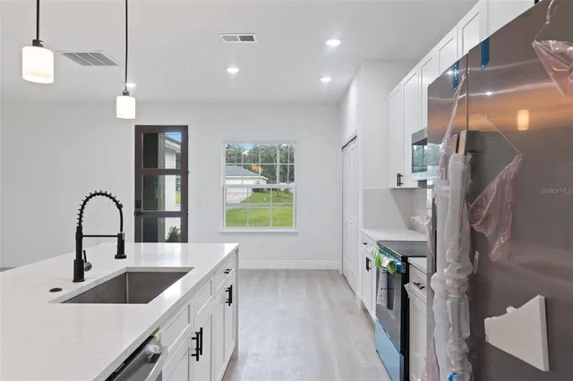 a kitchen with a sink and chandelier