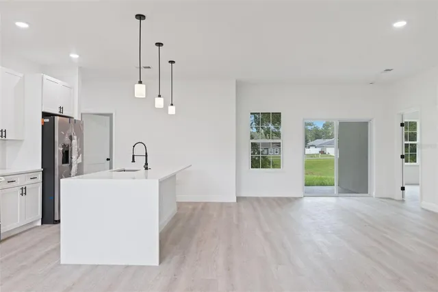 a view of a kitchen with stainless steel appliances refrigerator stove and wooden floor