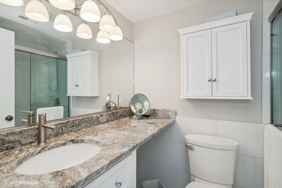 103 Viola Court Rolling Meadows, IL 60008 - Photo 16 of 27 a bathroom with a granite countertop sink a toilet and a mirror