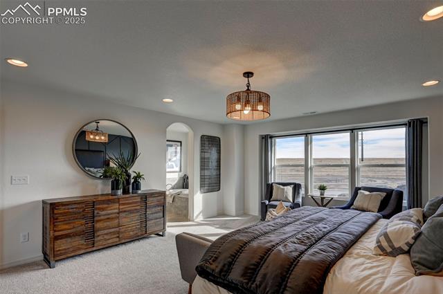 5057 Truscott Road Colorado Springs, CO 80925 - Photo 16 of 48 Bedroom featuring light colored carpet and a water view