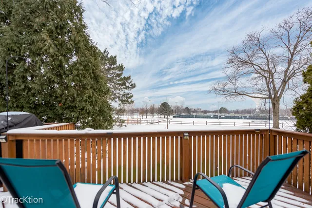 a view of a roof deck with wooden fence and trees