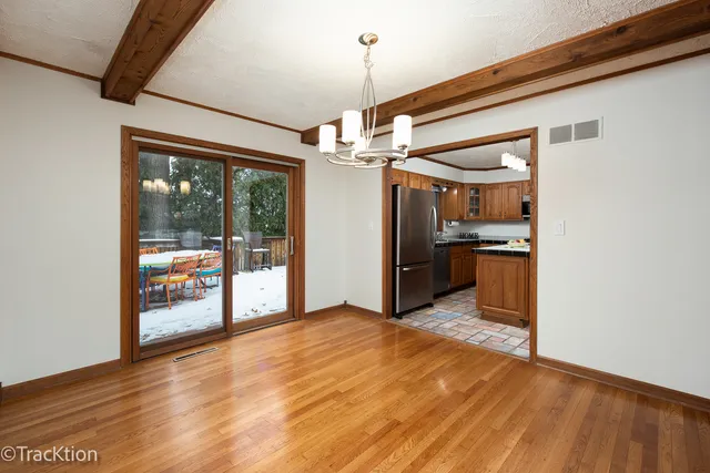 a view of a kitchen with refrigerator and wooden floor