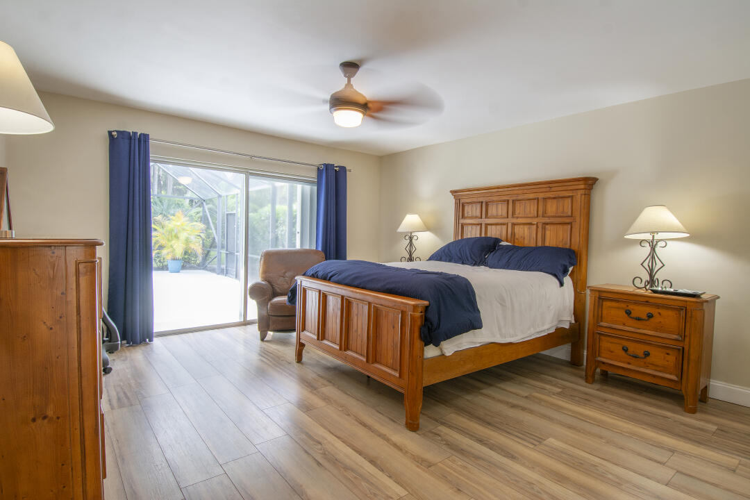 3372 Southeast Court Drive Stuart, FL 34997 - Photo 16 of 33 a bedroom with a bed and a chandelier