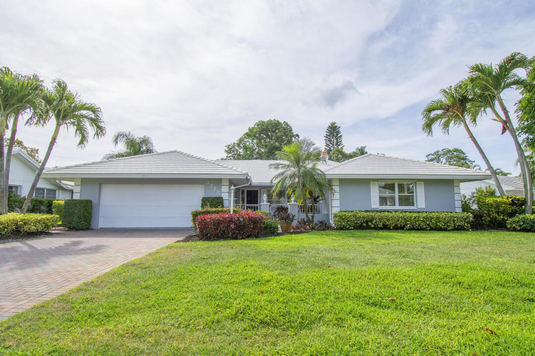 3372 Southeast Court Drive Stuart, FL 34997 - Photo 2 of 33 a front view of a house with a garden