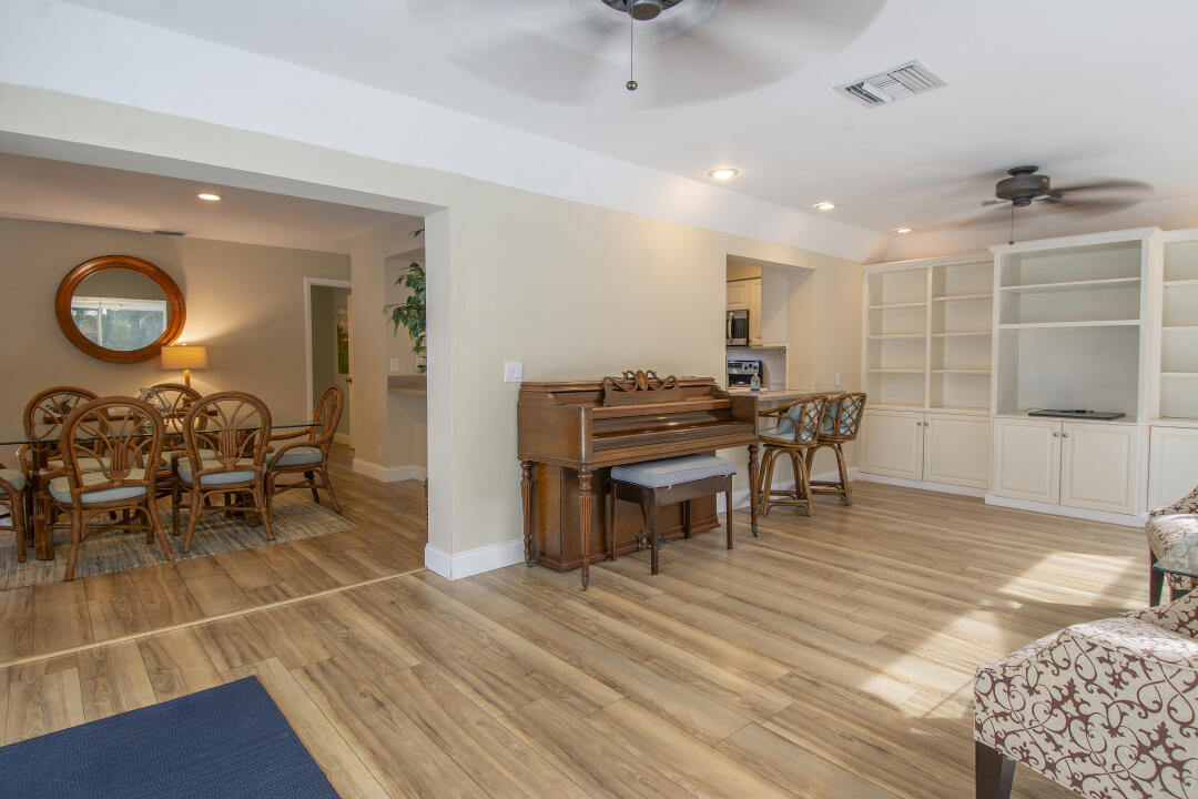 3372 Southeast Court Drive Stuart, FL 34997 - Photo 23 of 33 a living room with furniture a dining table and chairs with wooden floor