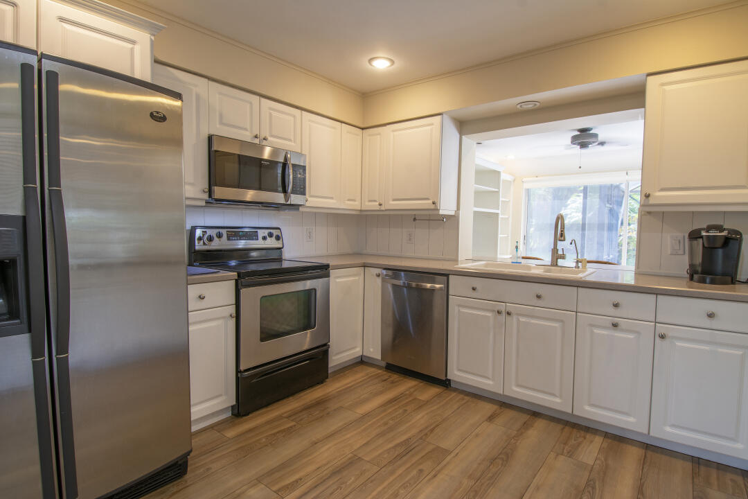 3372 Southeast Court Drive Stuart, FL 34997 - Photo 27 of 33 a kitchen with stainless steel appliances a refrigerator sink and microwave