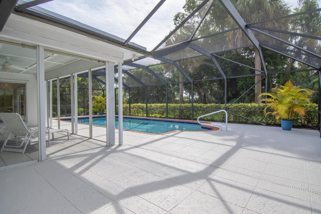 3372 Southeast Court Drive Stuart, FL 34997 - Photo 30 of 33 a view of a house with a floor to ceiling windows and a small yard