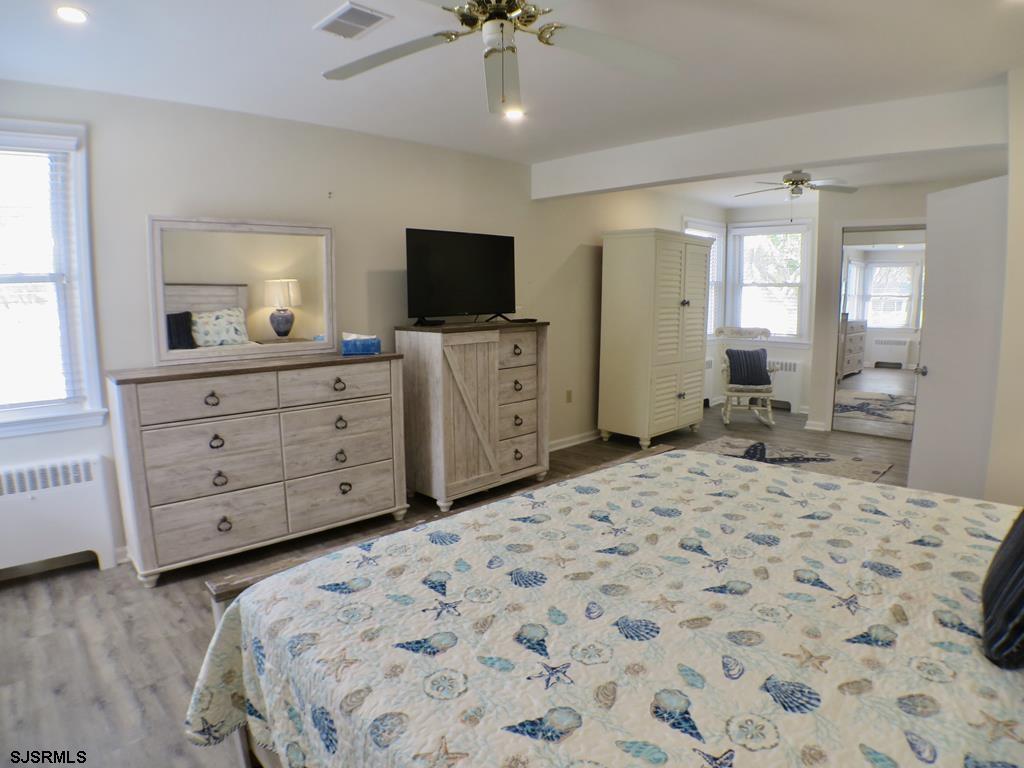 814 Wesley Road Ocean City, NJ 08226 - Photo 17 of 29 a bedroom with a large bed and a flat tv screen on dresser