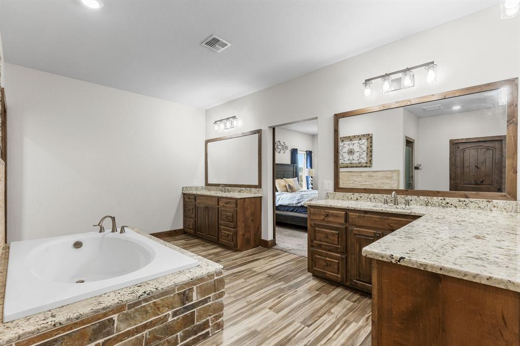 515 Sales Road Windthorst, TX 76389 - Photo 18 of 34 a spacious bathroom with a granite countertop sink and a bathtub