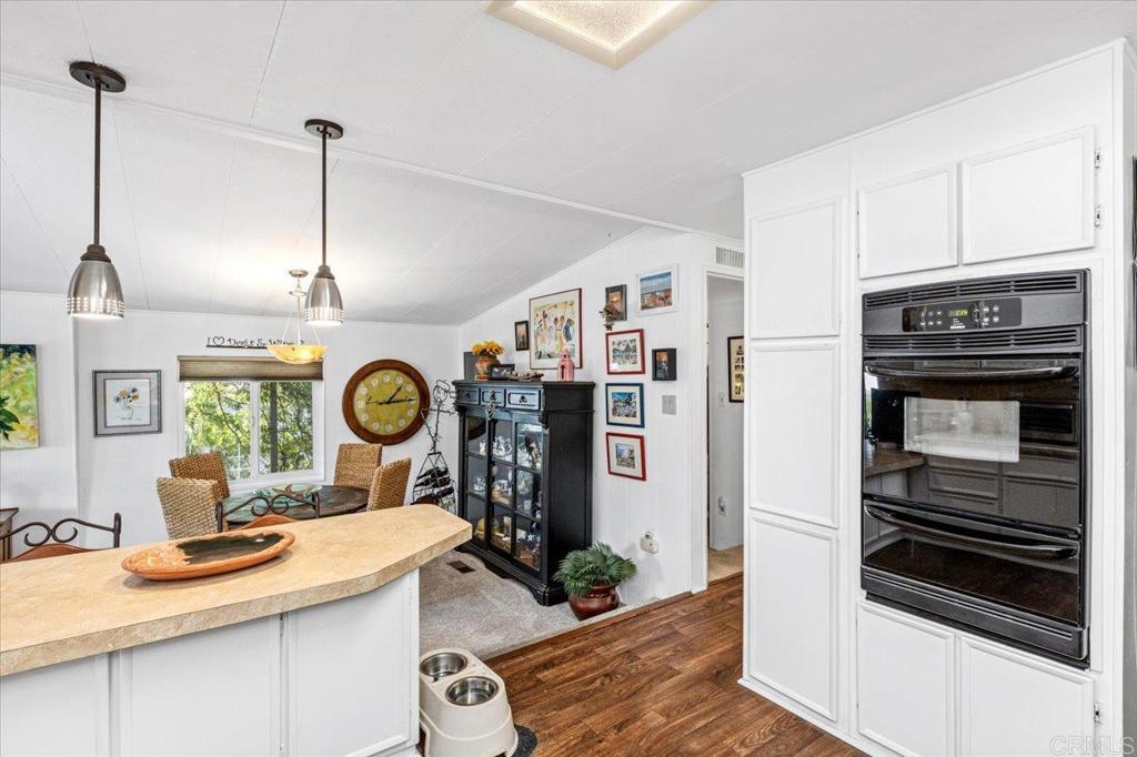 18218 Paradise Mountain Road, Unit 116 Valley Center, CA 92082 - Photo 14 of 35 a kitchen with a stove a refrigerator and a clock on the wall