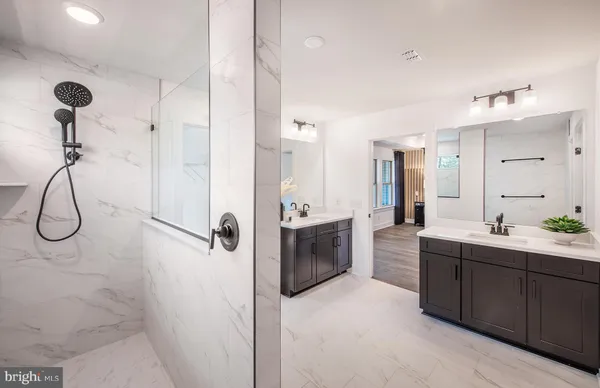 a bathroom with a double vanity sink mirror and shower