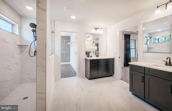 a bathroom with a double vanity sink toilet and shower